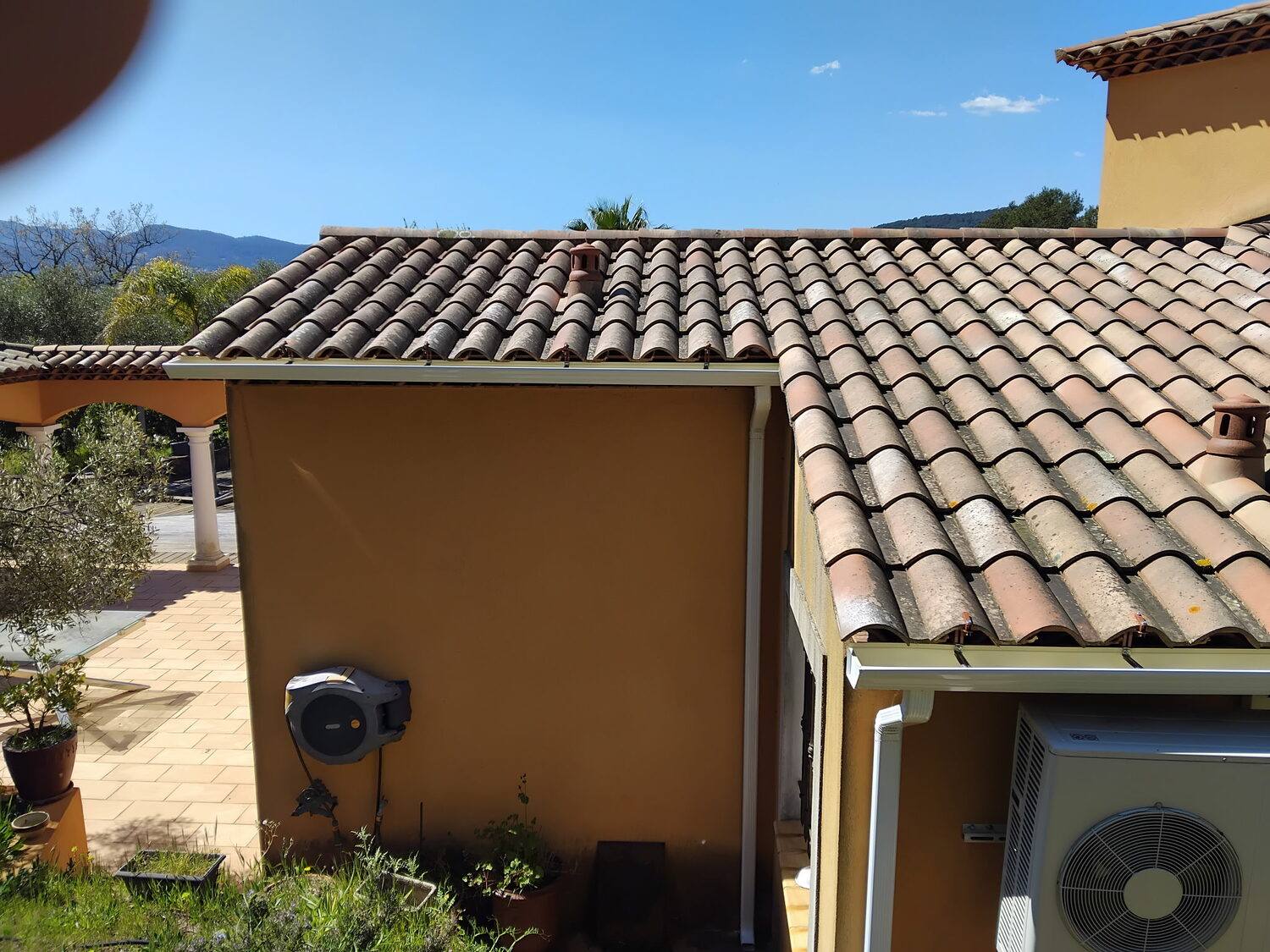 Gouttière et descente en aluminium laqué le long d'une façade dans le Var