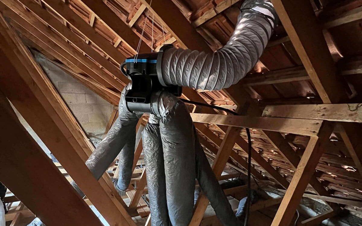 Caisson de VMC suspendu dans les combles avec ses gaines isolées